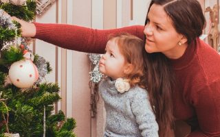 mãe e filha decorando uma árvore de natal