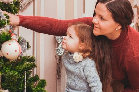 mãe e filha decorando uma árvore de natal