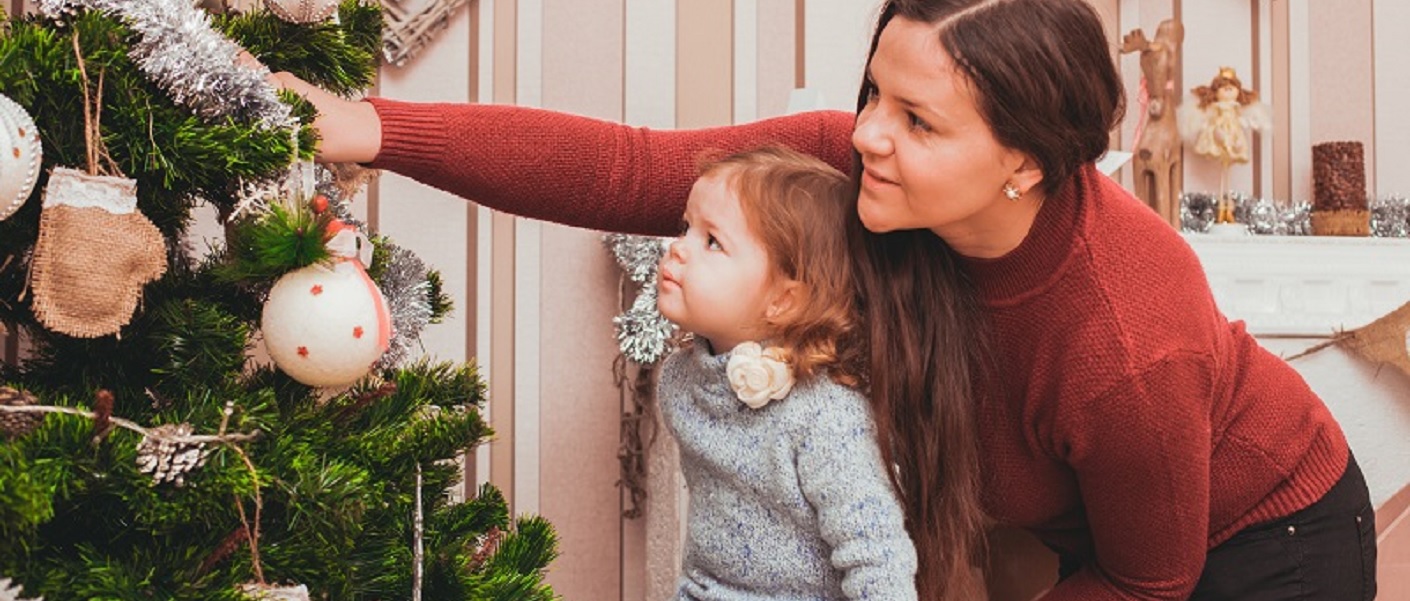 mãe e filha decorando uma árvore de natal