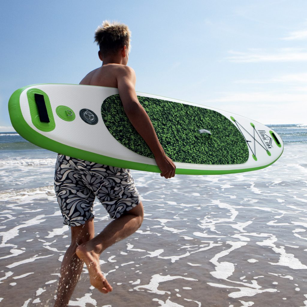 menino com uma prancha de paddle surf no mar 