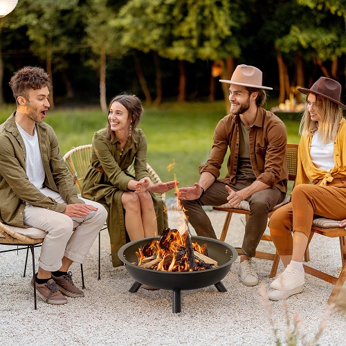 grupo de amigos conversando em volta de um braseiro ao ar livre 