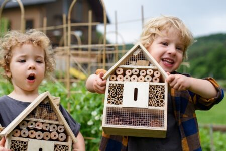 crianças segurando um hotel para insetos