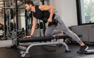 homem fazendo exercício com um halters em um banco de musculação