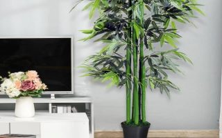 sala de estar com uma planta artificial na cor verde e um móvel com uma TV