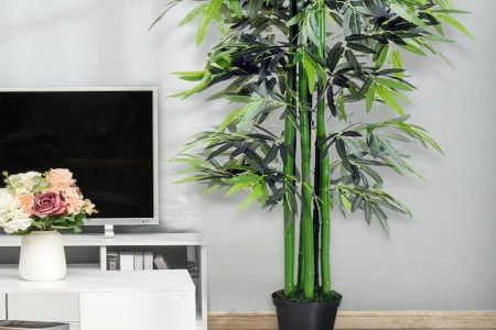 sala de estar com uma planta artificial na cor verde e um móvel com uma TV