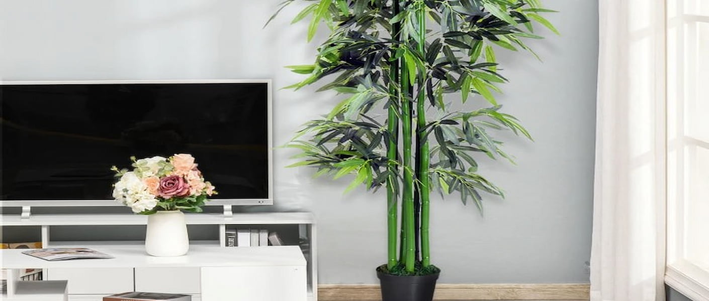 sala de estar com uma planta artificial na cor verde e um móvel com uma TV