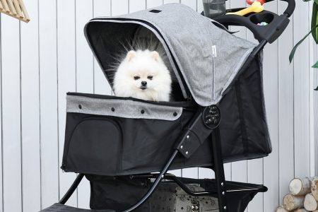 cão branco pequeno dentro de um carrinho de passeio na cor cinza e preto