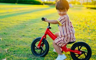 menino em uma bicicleta de equilíbrio no parque