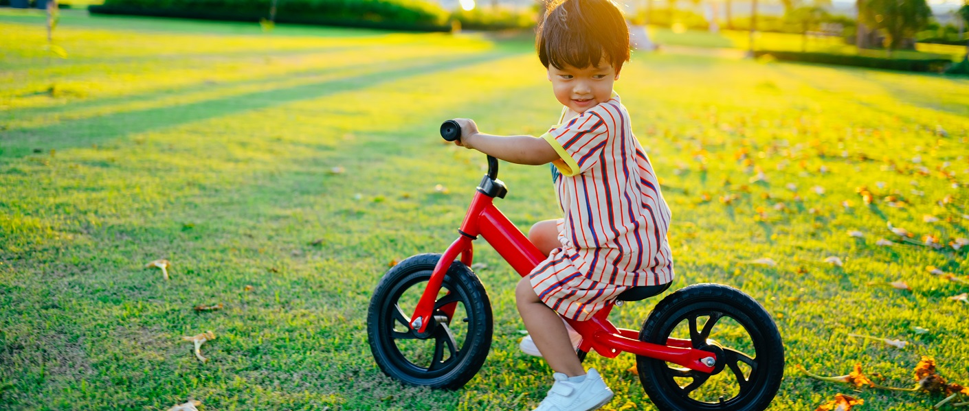 menino em uma bicicleta de equilíbrio no parque