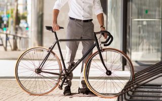 homem colocando uma bicicleta em um estacionamento de bicicletas