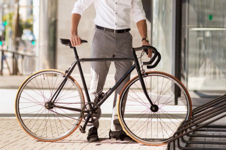 homem colocando uma bicicleta em um estacionamento de bicicletas