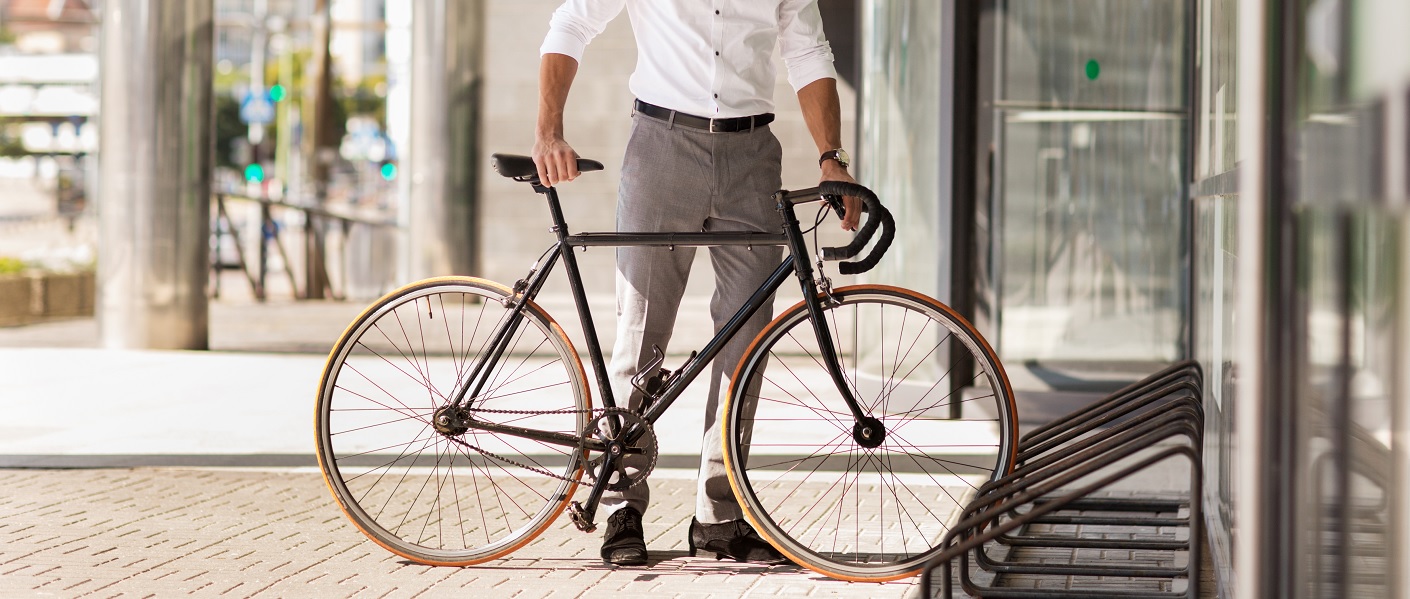 homem colocando uma bicicleta em um estacionamento de bicicletas