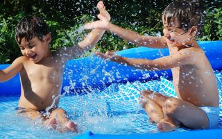 dois meninos brincando em uma piscina insuflável