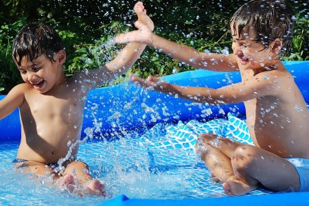 dois meninos brincando em uma piscina insuflável