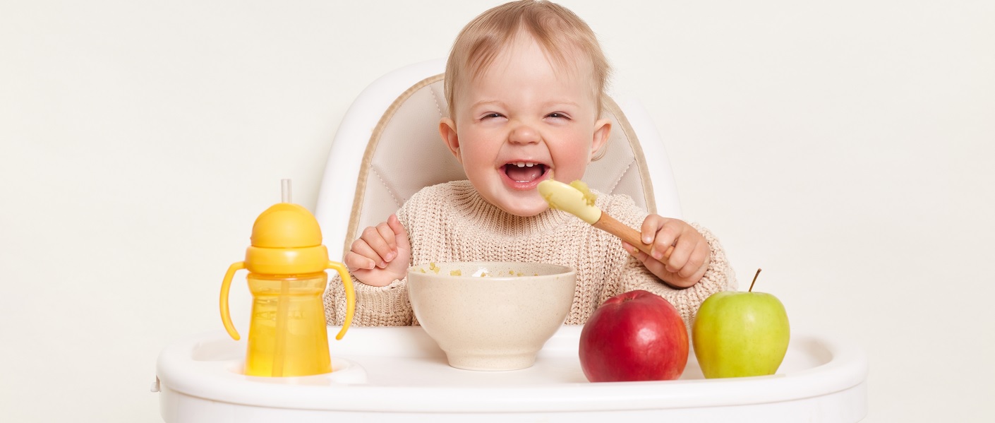 bebé comendo frutas em uma cadeira de refeição