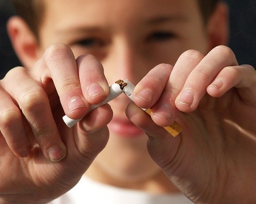 menino quebrando um cigarro