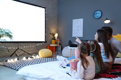 familia assistindo um filme em casa comendo pipoca