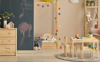 quarto infantil com cómoda, mesa e cadeira e diversos brinquedos infantis