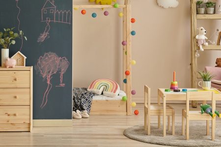 quarto infantil com cómoda, mesa e cadeira e diversos brinquedos infantis
