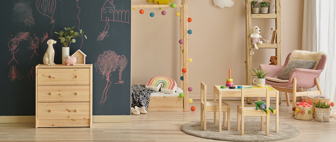 quarto infantil com cómoda, mesa e cadeira e diversos brinquedos infantis