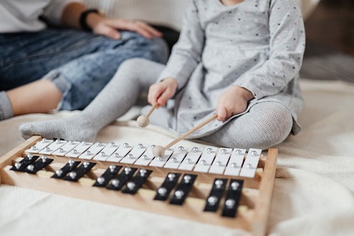 criança tocando um instrumento musical