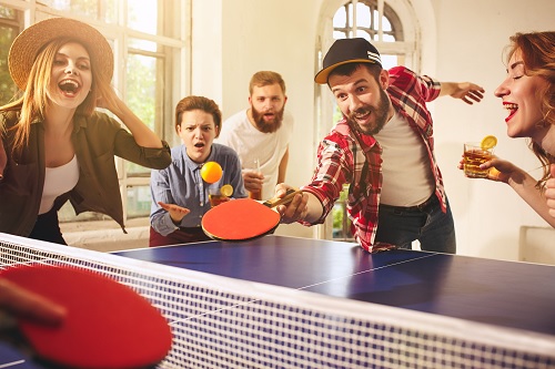 amigos jogando uma partida de ping pong