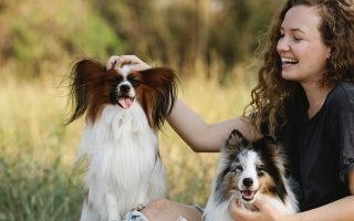 mulher passeando no parque com os seu dois cães