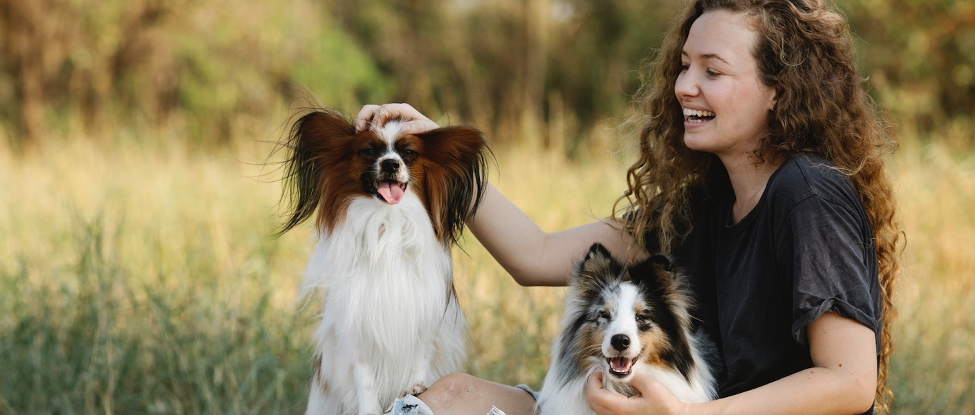 mulher passeando no parque com os seu dois cães