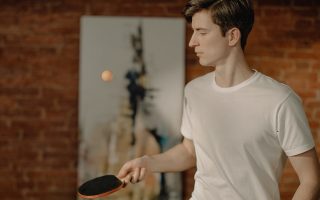 menino jogando ping pong