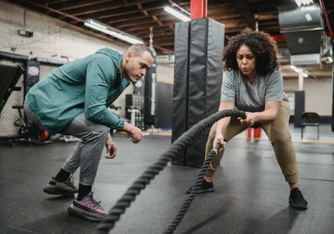 mulher praticando exercício com uma corda de batalha