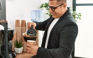 homem tomando café em uma estação de café no escritório