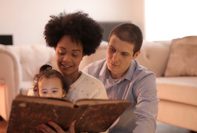 pais lendo um livro infantil para o seu filho