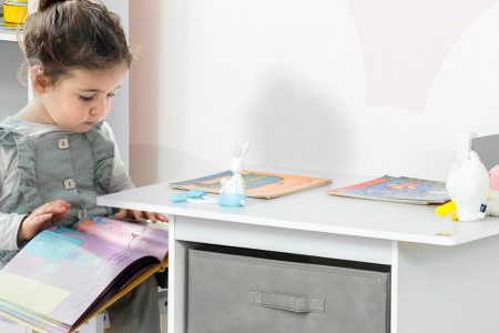 menina lendo um livro sentada em uma cadeira para crianças