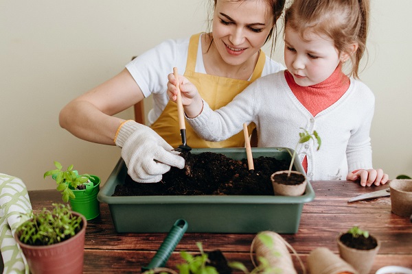 mãe e filha plantando plântulas 