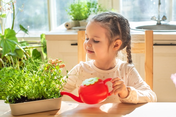 menina regando uma planta