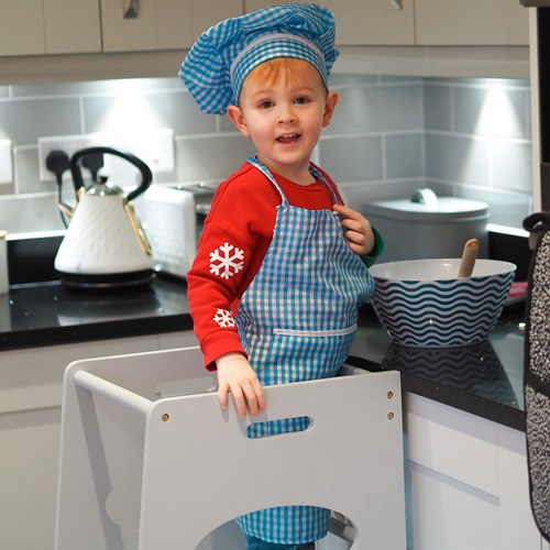 menino cozinhando com auxilio de uma torre de aprendizagem 