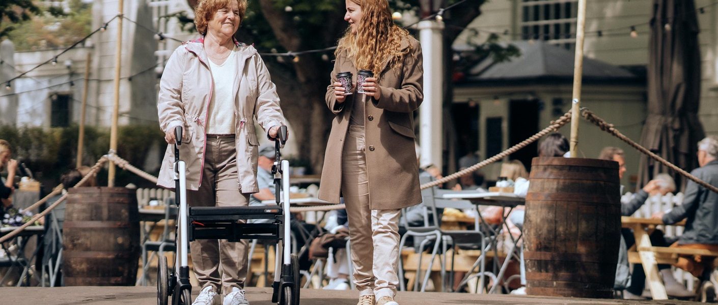 idosa caminhando com o auxilio de um andador