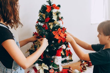 crianças decorando uma árvore de natal pequena