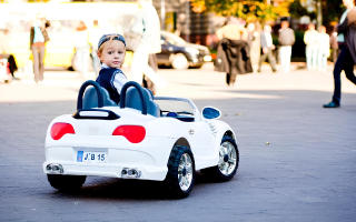 menino passeando com um carro elétrico branco