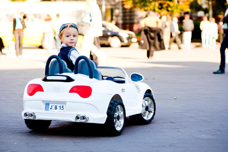 menino passeando com um carro elétrico branco